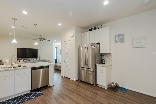 kitchen featuring a sink, dark wood-style floors, open floor plan, stainless steel appliances, and white cabinetry