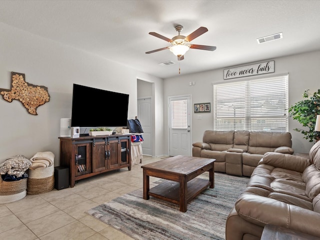living area featuring light tile patterned floors, visible vents, and a ceiling fan