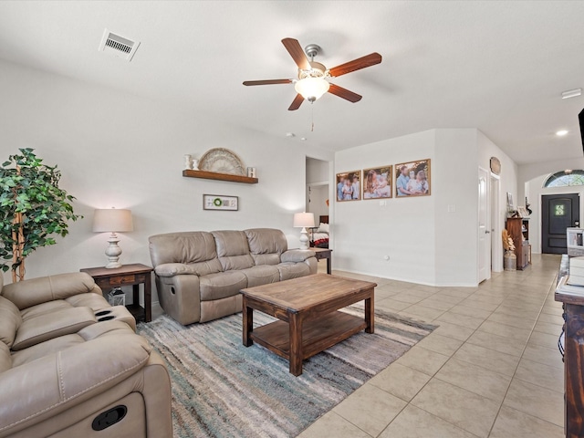 living area with light tile patterned floors, visible vents, baseboards, and a ceiling fan