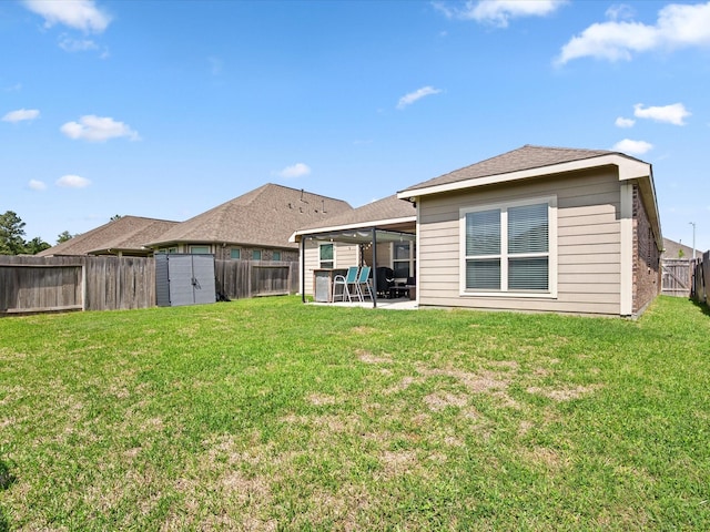 rear view of house with a storage unit, a fenced backyard, a patio, and an outbuilding