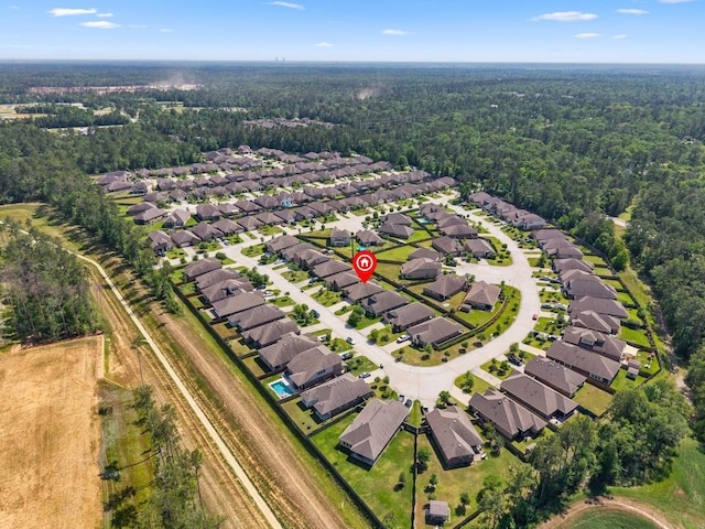 birds eye view of property featuring a wooded view and a residential view