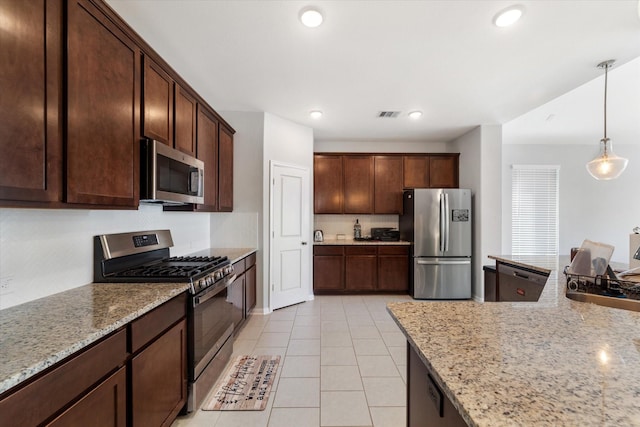 4430 Painted Bunting Ln, Baytown, TX 77521 - kitchen with pendant lighting, dark brown cabinets, light stone countertops, and stainless steel appliances