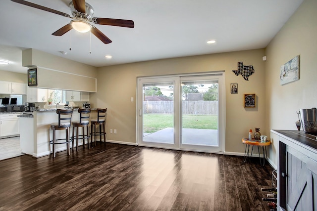 5522 Duxbury St, Houston, TX 77035 - kitchen featuring a kitchen bar, dark wood-style floors, white cabinetry, a peninsula, and ceiling fan