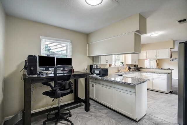 5522 Duxbury St, Houston, TX 77035 - home office with healthy amount of natural light, a sink, and light marble finish floors