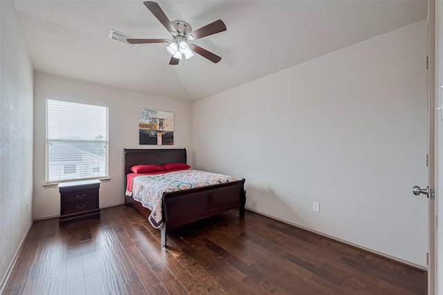 bedroom with ceiling fan, visible vents, and wood finished floors