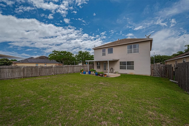 back of house with a fenced backyard, a yard, and a patio area