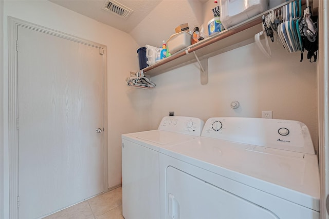 clothes washing area with laundry area, light tile patterned flooring, independent washer and dryer, and visible vents