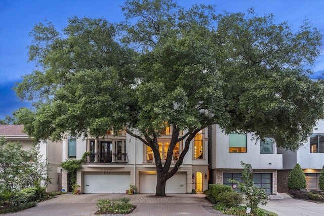 view of property featuring an attached garage, driveway, and stucco siding