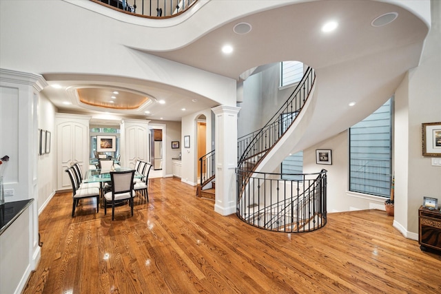 dining room featuring recessed lighting, arched walkways, ornate columns, and wood finished floors
