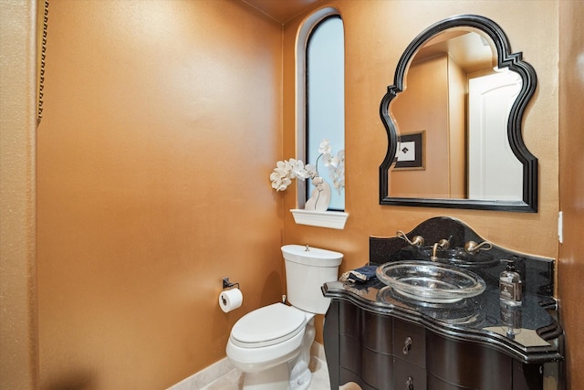 bathroom with tile patterned floors, vanity, baseboards, and toilet