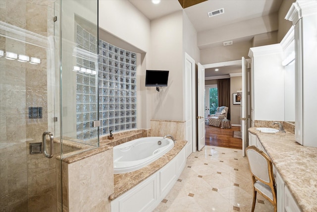ensuite bathroom with connected bathroom, a shower stall, vanity, visible vents, and a whirlpool tub