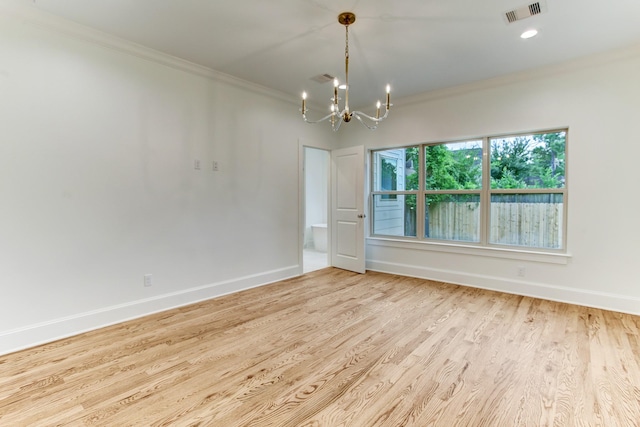 spare room featuring visible vents, baseboards, ornamental molding, light wood-type flooring, and a chandelier