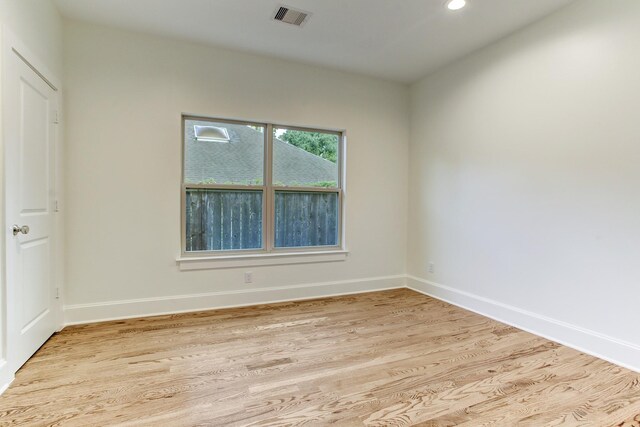 empty room with recessed lighting, visible vents, light wood-type flooring, and baseboards
