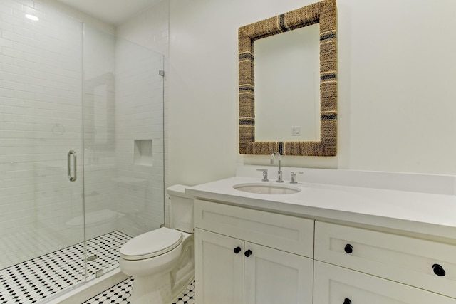 bathroom featuring toilet, a shower stall, and vanity
