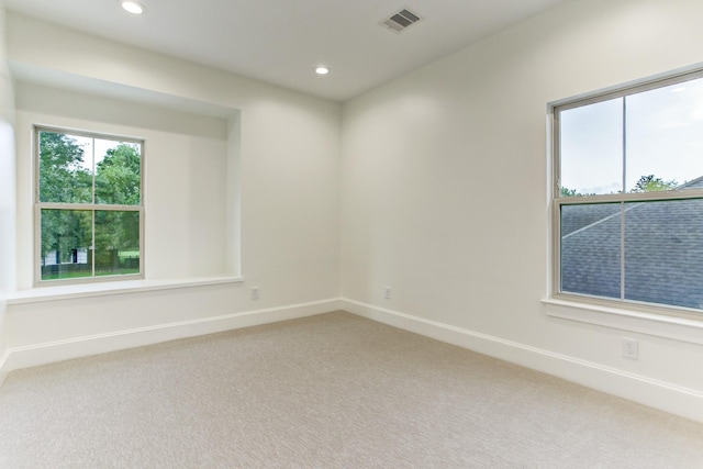 spare room featuring visible vents, baseboards, recessed lighting, and light carpet
