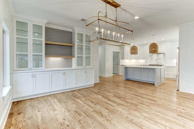 kitchen with light wood-style floors, a sink, and white cabinetry