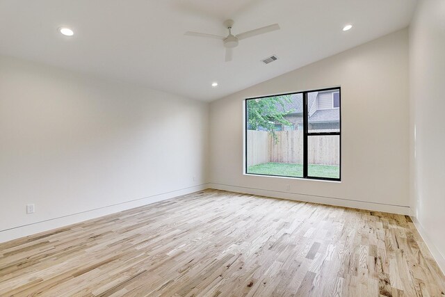 empty room featuring recessed lighting, light wood-style flooring, and vaulted ceiling
