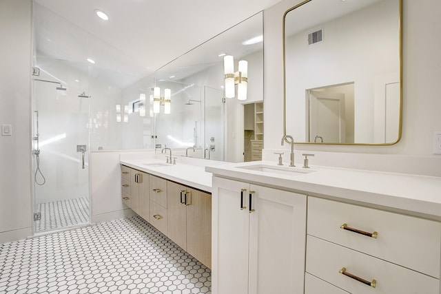 full bath with a shower stall, double vanity, a sink, and visible vents