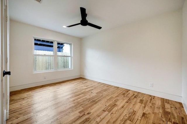 empty room with baseboards, a ceiling fan, and wood finished floors