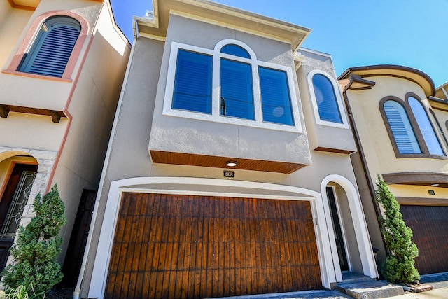 mediterranean / spanish house with a garage and stucco siding