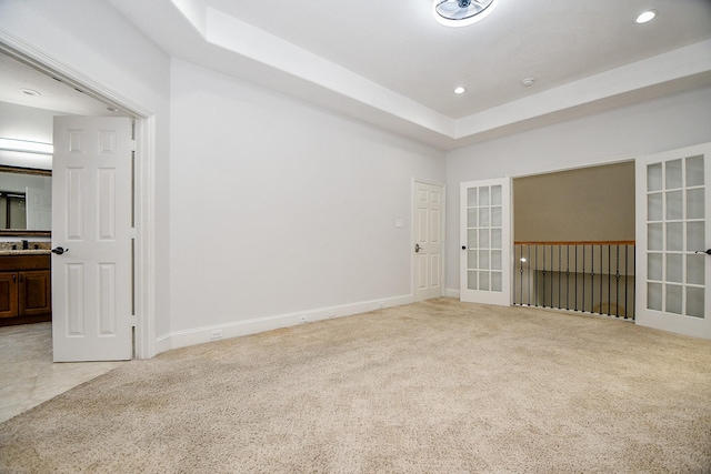 unfurnished room with baseboards, recessed lighting, french doors, light colored carpet, and a sink