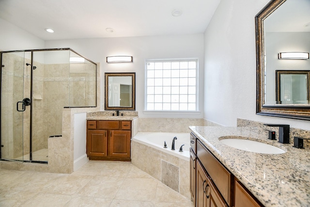 bathroom with a shower stall, a bath, two vanities, and a sink