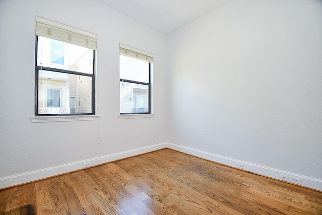 spare room with light wood-type flooring and baseboards