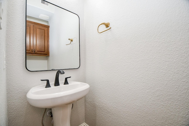 bathroom with a sink and a textured wall