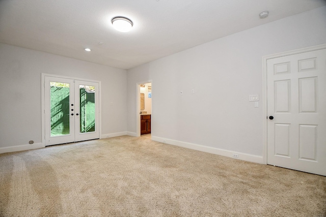 unfurnished room featuring french doors, light colored carpet, and baseboards