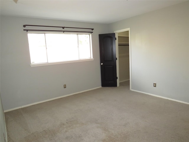 unfurnished bedroom featuring baseboards, carpet flooring, and a closet