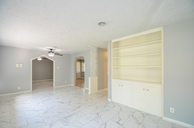 6606 Flamingo Dr, Houston, TX 77087 - empty room with arched walkways, baseboards, a textured ceiling, and ceiling fan