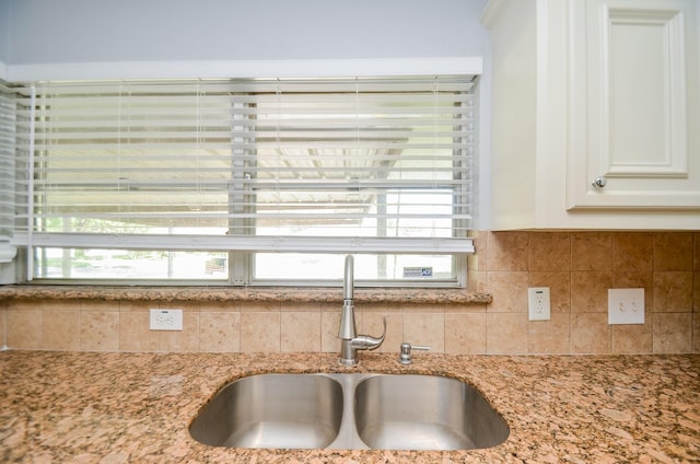 6606 Flamingo Dr, Houston, TX 77087 - room details with tasteful backsplash, light stone counters, a sink, and white cabinetry