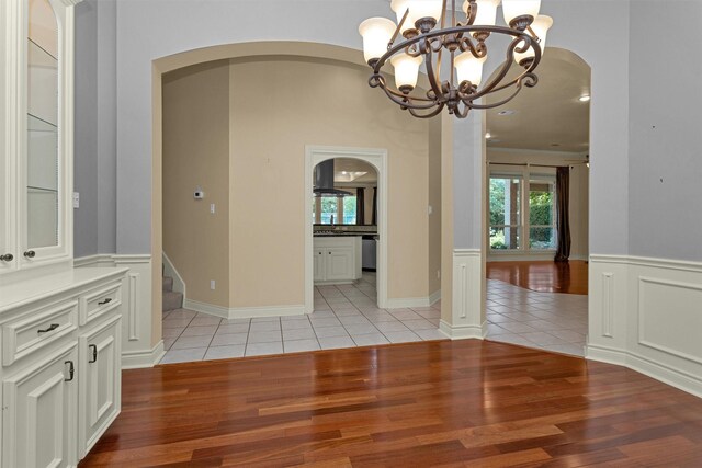 110 Wick Willow Dr, Montgomery, TX 77356 - unfurnished dining area with arched walkways, a chandelier, and light tile patterned floors