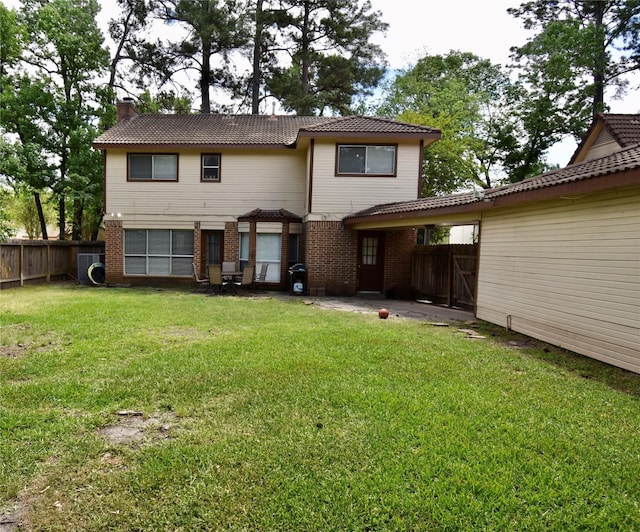 rear view of house featuring brick siding, a chimney, and a patio