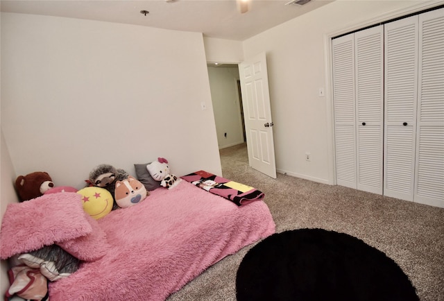 carpeted bedroom featuring a closet, baseboards, and a ceiling fan