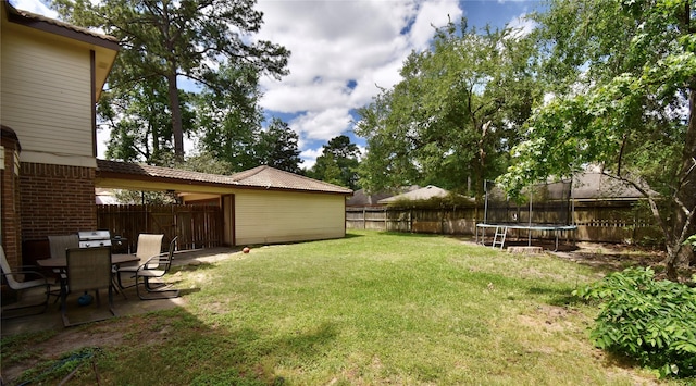view of yard featuring a trampoline and a patio
