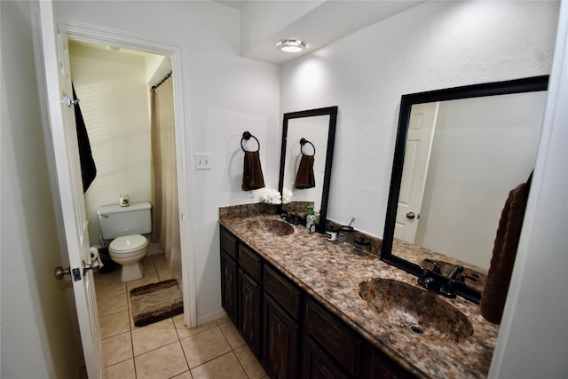 full bathroom featuring tile patterned flooring, toilet, and double vanity