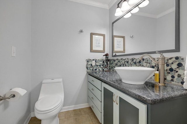 bathroom with ornamental molding, toilet, vanity, and baseboards