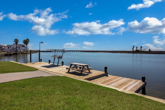 dock area with a yard and a water view