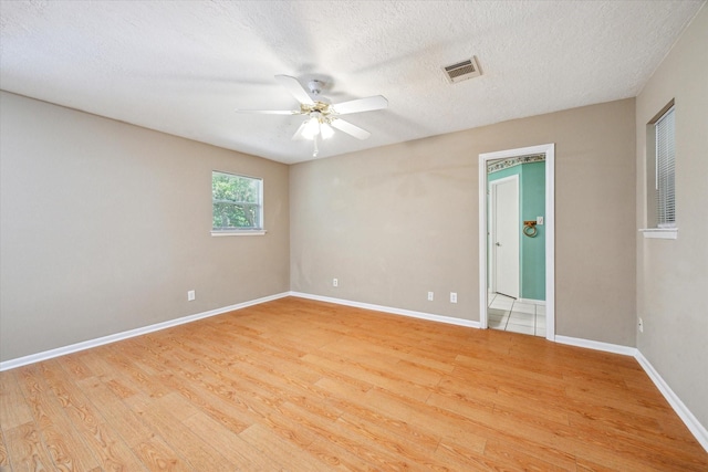 unfurnished room featuring ceiling fan, baseboards, light wood-style floors, and visible vents