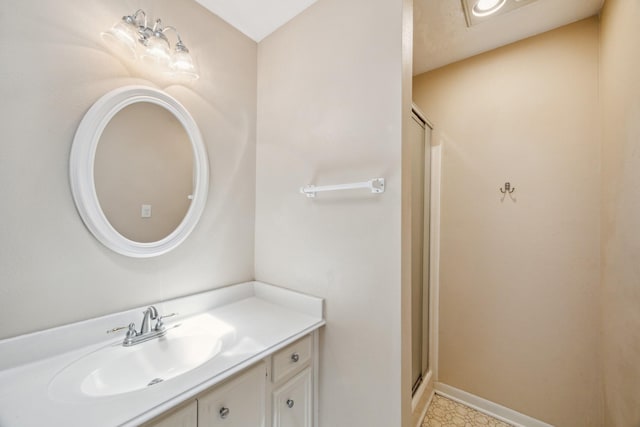full bathroom with baseboards, vanity, and a stall shower
