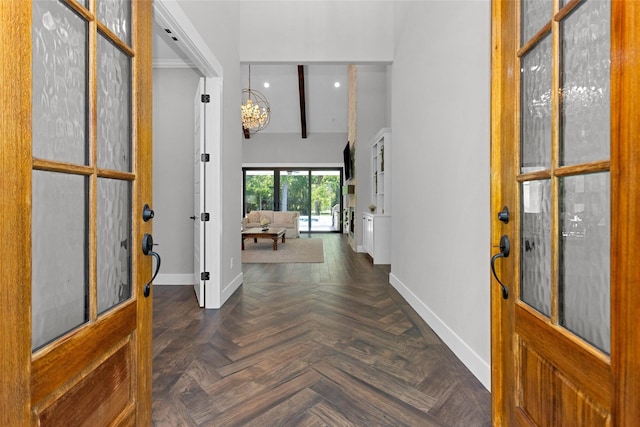 foyer entrance with baseboards, a chandelier, a high ceiling, and recessed lighting