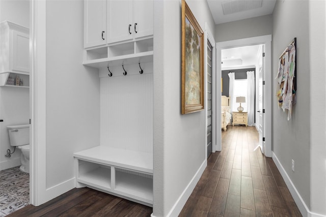 mudroom featuring dark wood finished floors, baseboards, and visible vents