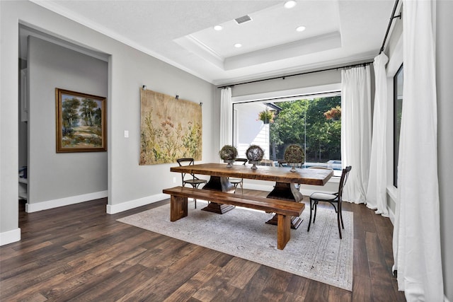 dining space with recessed lighting, a raised ceiling, ornamental molding, dark wood-type flooring, and baseboards