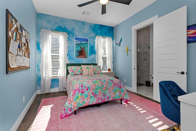bedroom with wood finished floors, visible vents, a ceiling fan, an accent wall, and baseboards