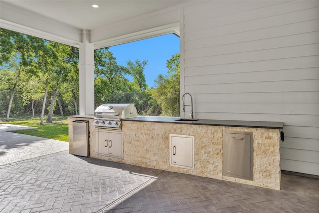 view of patio / terrace featuring grilling area, an outdoor kitchen, and a sink