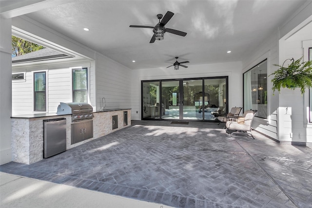 view of patio / terrace with an outdoor kitchen, ceiling fan, and a grill
