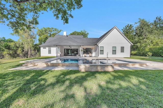 back of property featuring a lawn, an outdoor pool, a patio area, and a ceiling fan
