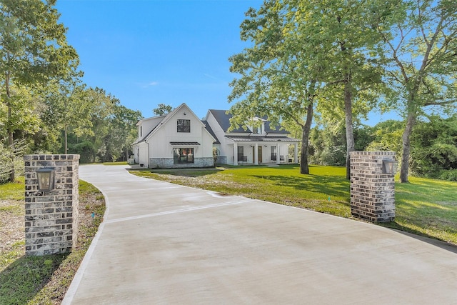 11799 N Peppertree Loop, Montgomery, TX 77356 - view of front of property with a front yard, board and batten siding, driveway, and stone siding