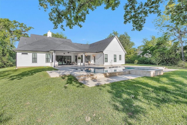 rear view of house with an in ground hot tub, a lawn, a patio, ceiling fan, and an outdoor pool